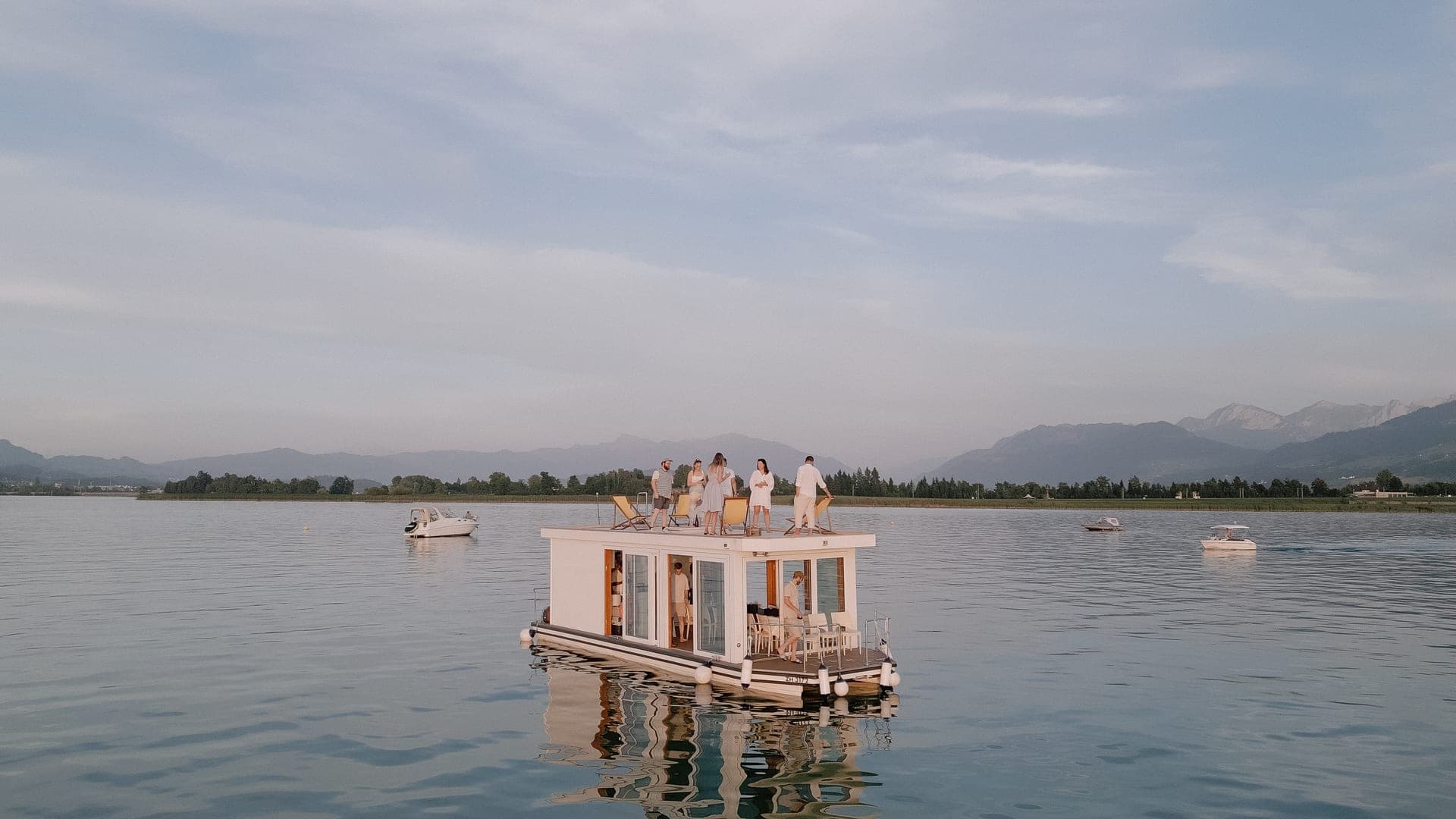 Drohnenaufnahme des Eventflosses bei Sonnenuntergang, spiegelglatter Zürichsee